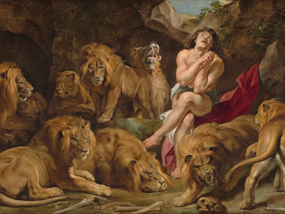 A nearly nude, muscular man with pale, peachy skin sits in an underground cave among seven male and two female lions in this horizontal painting. The man sits to our right of center with his legs crossed, elbows close to his body with hands clasped by his chest. His head tips back to look up through a small opening above. He has long, wavy, chestnut-brown hair and dark eyes. A white cloth wraps across his hips, and he sits on a scarlet-red swath of fabric draped up over a rock next to him. The nine lions stalk, sit, or lie down around the man. One male lion next to the man, to our left, opens his mouth with his head thrown back, curling tongue extended beyond long fangs. A human skull and other bones are strewn on the dirt ground close to us. The rocky cave curves up around the animals and man to a narrow, round opening showing blue sky above.