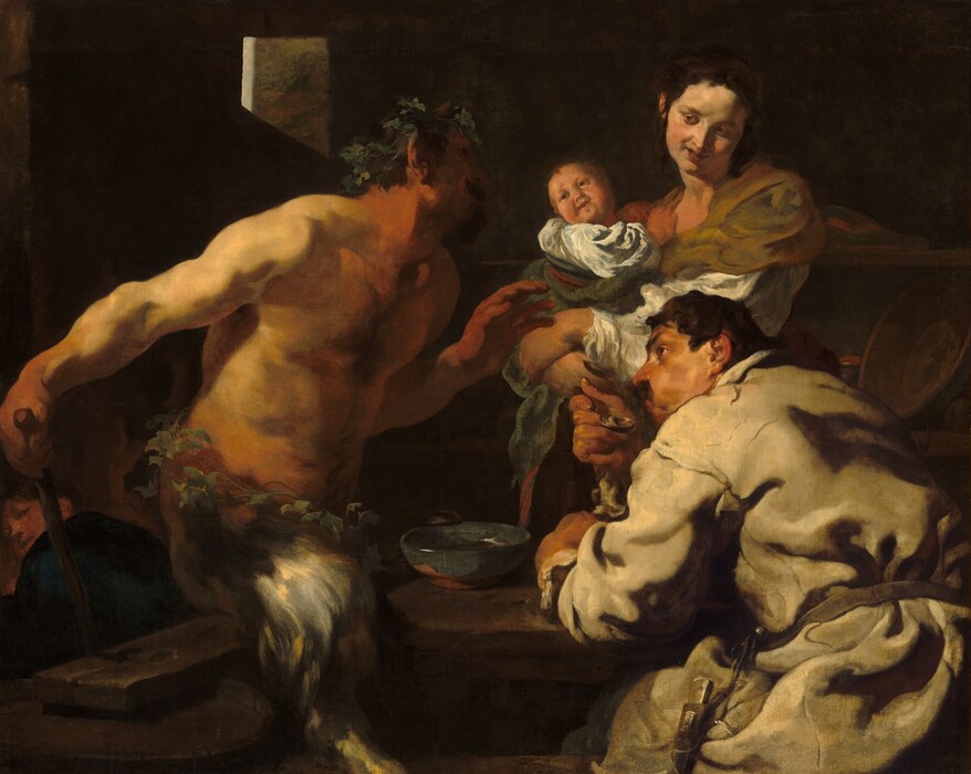 Shown from the about the thighs up, a man, a woman holding a swaddled baby, and a satyr, which has a man’s torso and goat’s legs, sit and stand around a table in a deeply shadowed room, filling this horizontal painting. All the people have light skin and dark hair, and are lit dramatically from our left. To our left, the bare-chested satyr faces our right in profile as he leans toward the table, looking up at the woman. He wears a crown of leaves and has a dark goatee. Almost lost in shadow, a sable-brown horn juts up from his temple. Light falls across his bare shoulders, and his hands and neck are ruddy. Another ring of leaves encircles his waist over the silvery-gray fur of his goat’s legs. He holds his left hand, farther from us, in front of his chest with his open palm facing the couple to our right. His other hand rests at the top of a wooden staff behind his right hip, closer to us. The staff disappears behind a wood plank resting across at least one barrel, which presumably acts as the bench on which he sits on or hovers slightly over. The second man sits at the table to our right, his back mostly to us as he looks over his left shoulder, up toward the satyr, with his face in profile. One brow is cocked over the dark eye we can see, and he has a prominent nose and a mustache. He wears a loose-fitting, long-sleeved, white garment tied around the waist. He blows across a soup spoon held to his lips, his cheeks puffed. He leans on his other arm, which rests on the tabletop near a blue bowl. Across the table, behind the seated man, a woman looks back at the satyr from the corners of her eyes, her coral-red lips curled up in a smile. Her body faces our left and she tilts her head to her left, our right, as she turns her face down toward that shoulder. Her dark brown hair is pulled up and back, and she wears an olive-green wrap over a white shirt. The baby she holds leans away from her chest to twist and look back at the satyr as well. A few details eventually emerge from the deeply shadowed background, including a fourth person tucked into the lower left corner, who looks back over a shoulder at us or the group. Light rims the corner of a window cut from a stone wall, and a few ceramic dishes and cups line two shelves to our right behind the woman.