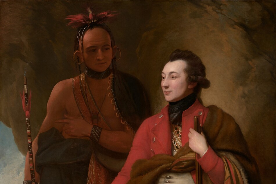 A man with pale white skin sits and a man with light brown skin stands in front of a cave-like, rocky outcropping in this vertical portrait painting. The light-skinned man closer to us has dark brown hair, and the light falls more strongly on him. He sits propped on or against a rock with his body angled to our left, and he looks off into the distance in that direction. He wears a scarlet-red overcoat, a white waistcoat, and moccasins. What appears to be an animal skin painted on the underside with red, tan, and black geometric patterns is tied around his chest and falls over his left arm, on our right. With that hand, he holds a musket like a walking stick. He also holds a black cap ornamented with beads and feathers on his other knee. The man with brown skin stands in shadow behind the other man, to our left. His body faces us, and he looks at the seated man. A dark cloak encircles his shoulders and is gathered around his waist. A strap crosses his bare chest and the strap, bracelets, and a feathered headdress seem to be beaded. Large gold rings curve from his earlobes up over his ears. A puff of smoke emerges from the top of the long, painted stick he holds, suggesting it is a pipe. He holds his left hand, on our right, at his chest, and points subtly to our left, perhaps to the landscape seen through a break in the rocky outcropping. There, in front of a waterfall in the distance, a small group of people with light brown skin gather around a camp fire in front of a tent-like structure.