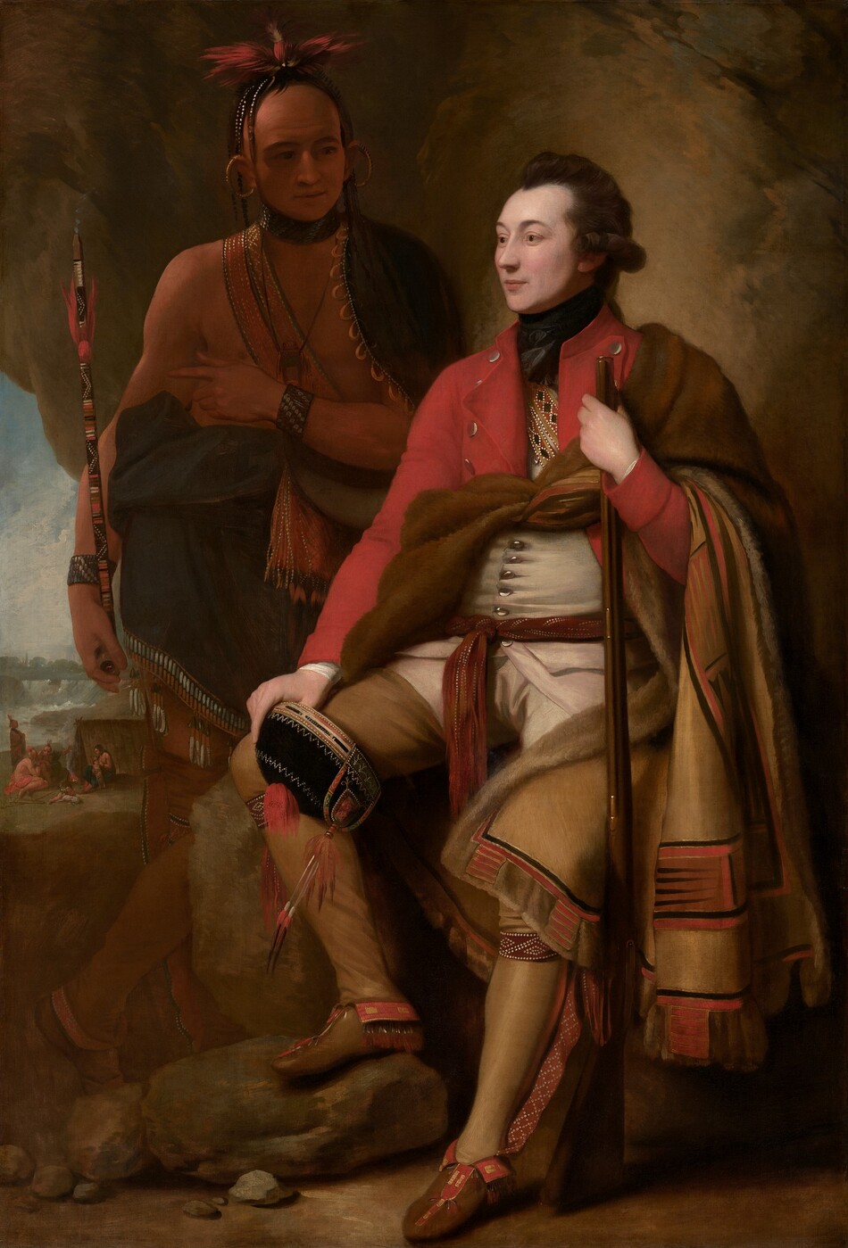 A man with pale white skin sits and a man with light brown skin stands in front of a cave-like, rocky outcropping in this vertical portrait painting. The light-skinned man closer to us has dark brown hair, and the light falls more strongly on him. He sits propped on or against a rock with his body angled to our left, and he looks off into the distance in that direction. He wears a scarlet-red overcoat, a white waistcoat, and moccasins. What appears to be an animal skin painted on the underside with red, tan, and black geometric patterns is tied around his chest and falls over his left arm, on our right. With that hand, he holds a musket like a walking stick. He also holds a black cap ornamented with beads and feathers on his other knee. The man with brown skin stands in shadow behind the other man, to our left. His body faces us, and he looks at the seated man. A dark cloak encircles his shoulders and is gathered around his waist. A strap crosses his bare chest and the strap, bracelets, and a feathered headdress seem to be beaded. Large gold rings curve from his earlobes up over his ears. A puff of smoke emerges from the top of the long, painted stick he holds, suggesting  it is a pipe. He holds his left hand, on our right, at his chest, and points subtly to our left, perhaps to the landscape seen through a break in the rocky outcropping. There, in front of a waterfall in the distance, a small group of people with light brown skin gather around a camp fire in front of a tent-like structure.