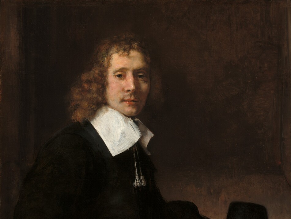 Shown from the hips up, a young man with pale skin and wearing black clothing sits with his body angled to our right as he turns to look at us in this vertical portrait painting. He looks out with green eyes under hooded lids. Light falls across his face from the upper left so his bumped nose casts a shadow on his high cheekbone. He has a wispy mustache over full, pink lips, which are slightly parted. His hair falls to his shoulders in auburn-brown curls, framing his slender face. Two silvery tassels hang on cords from a tall, wide, flat, bright white collar, which contrasts with the velvety black of his voluminous, long-sleeved jacket. His left hand, farther from us, rests on his knee and the other hand is curled so the back of his knuckles press against his right hip, closer to us. A patch of crimson red near that hand could be a pillow on his chair. His hat rests, presumably on a table, just beyond his legs. The hat has a tall, tapering, conical crown with a flat top. The shadowy wall behind him is mottled with slate gray and caramel brown, with a slightly darker panel to suggest a shallow niche.