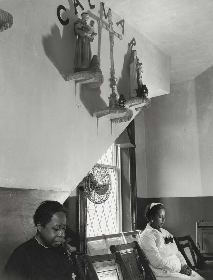 Washington, D.C. Sitting beneath the emblem of the crucifixion of Jesus on Calvary. Two members of the St. Martin's Spiritual Church listen and pray.