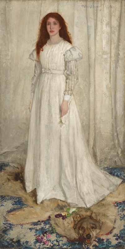 A young woman with pale, peachy skin, wearing a long, flowing white dress, stands in front of a white curtain in this vertical portrait painting. Her auburn-red hair cascades down over and behind her shoulders. She looks to our left with green eyes, and her pink, full lips are closed. Her dress has puffed shoulders above a white-on-white striped pattern on the long sleeves. She stands on an animal pelt; it is not clear whether it is a wolf or a bear. The pelt spans the width of the painting and overlaps a blue patterned carpet. The animal’s mouth gapes to show sharp teeth. Its glassy eyes are wide open, and it seems to look at us. The edges of the animal skin are red. The woman holds a white lily by her side in her left hand, while yellow and purple flowers lie scattered on the pelt.