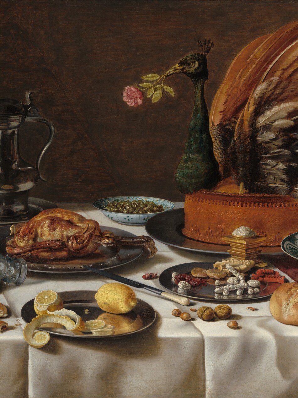 On a tabletop spread with an ivory-white cloth, plates, and white porcelain bowls containing sweets, fruit, olives, and a cooked fowl are arranged around the largest platter, which holds the head, wings, and tail of a peacock stuck into a tall, baked pie, in this horizontal still life painting. The front, left corner of the table is near the lower left corner of the painting, so the tabletop extends off the right side of the composition. The white tablecloth lies over a second cloth underneath, which is only visible along the right edge. The cloth underneath has a leafy, geometric pattern in burgundy red against a lighter, rose-red background. The peacock pie is set near the back of the table, to our right, so it fills the upper right quadrant of the composition. The bird holds a pink rose in its beak. In front of it, near the lower right corner of the painting, a white porcelain bowl painted with teal-green floral and geometric designs holds about ten pieces of pale yellow and blush-red fruit. A pewter plate next to it, to our left, holds dried fruit and baked, stick-like sweets, some covered with white sugar. A pile of salt sits atop a gold, square vessel between the sweets and the peacock pie. Another blue-patterned, white porcelain bowl filled with green olives sits near the back of the table next to a lidded, pewter pitcher with a long spout. Other pewter plates hold a baked fowl, like a small chicken, and, closest to us, a partially cut lemon with its peel curling off the plate. Nuts, more fruit, an ivory-handled knife, bread rolls, and flat biscuits sit on the white cloth among the plates. One glass with a wide stem covered in nubs and a flaring bowl sits near the back, left corner of the table, filled with a pale yellow liquid. An empty glass lies with the upper rim on another pewter plate, to our left. Also on the plate is a bunched up white napkin and a leather case for the knife. The background behind the still life is brown.