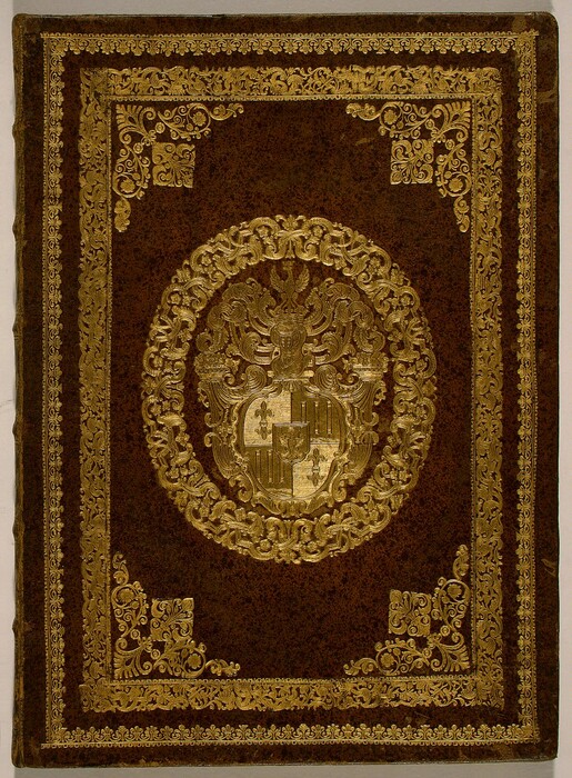 This is a photograph of a book cover. The cover is dark brown with gold embossing. The central design features a coat of arms surrounded by flourishes and scrollwork. The edges of the cover also have gold embellishments.