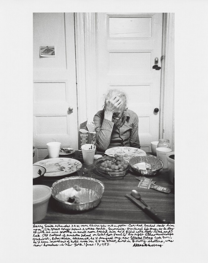 Harry Smith exhausted 3 A.M. over Chinese take-out supper. Car had backed into him up on 12th Street corner Avenue A weeks earlier, compression-fractured his knee, so he stayed with me nine months in small room behind him he’d fixed with door-latch and lock. Old postcard of Manhattan Island on toilet door panel to his right. Ethnomusicologic archivist, film-maker, alchemist, he’d designed my new _Collected Poems_ book cover, he’d been moved out of hotel room on 28’th Street, lived in Bowery shelters, was now homeless in New York! June 17, 1985.