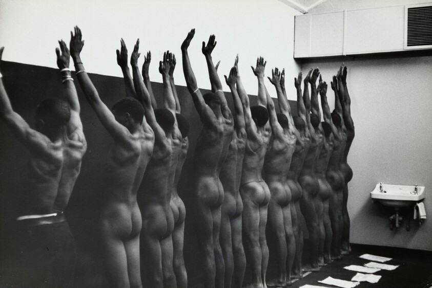 During group medical examination, the nude men are herded through a string of doctor’s offices