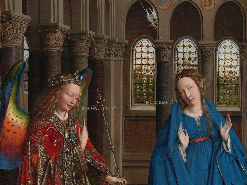 A woman and winged angel, both with pale, peach skin, are situated in a church interior in this tall, narrow painting. To our left, the angel has long, blond, curly hair, smooth skin, and is smiling. The wings are outlined in royal blue, and they blend from blue to green to yellow to crimson. The angel holds one hand, closer to us, up at chest height with the index finger subtly pointing upward. Holding a long scepter in the other hand, the angel angles their body toward the woman to our right. The angel wears a gold jewel and pearl-encrusted crown and a jeweled long, voluminous robe in scarlet-red and shimmering gold brocade. The neck and along the opening down the front are lined with pearls and jewels. The angel looks toward the woman, who wears a royal-blue dress tied with a red belt at the high waist. Her long brown hair is tied back but one tendril falls over her left shoulder, to our right. She kneels facing us with her raised hands facing outward. Her head is tipped a bit to our left, and she looks up and into the distance to our right with lips slightly parted. She kneels behind a book lying open on a low table. A vase of white lilies and a red cushion lies on the floor in front of the table, close to us. The floor is decorated with people and scenes outlined in black and set into square panels, as if inlaid with wood. The church behind and above the people has a row of tall, narrow arches with bull’s-eye glass windows. A walkway lined with columns runs above the arches, and sunlight comes in through arched windows under the flat wood ceiling. A white dove flies toward the woman on gold lines from a window at the upper left of the painting. Latin words painted in gold capital letters are exchanged between the people. The angel says, “AVE GRA PLENA.” The letters of the woman’s response are painted upside down and backward: “ECCE ANCILLA DNI.”