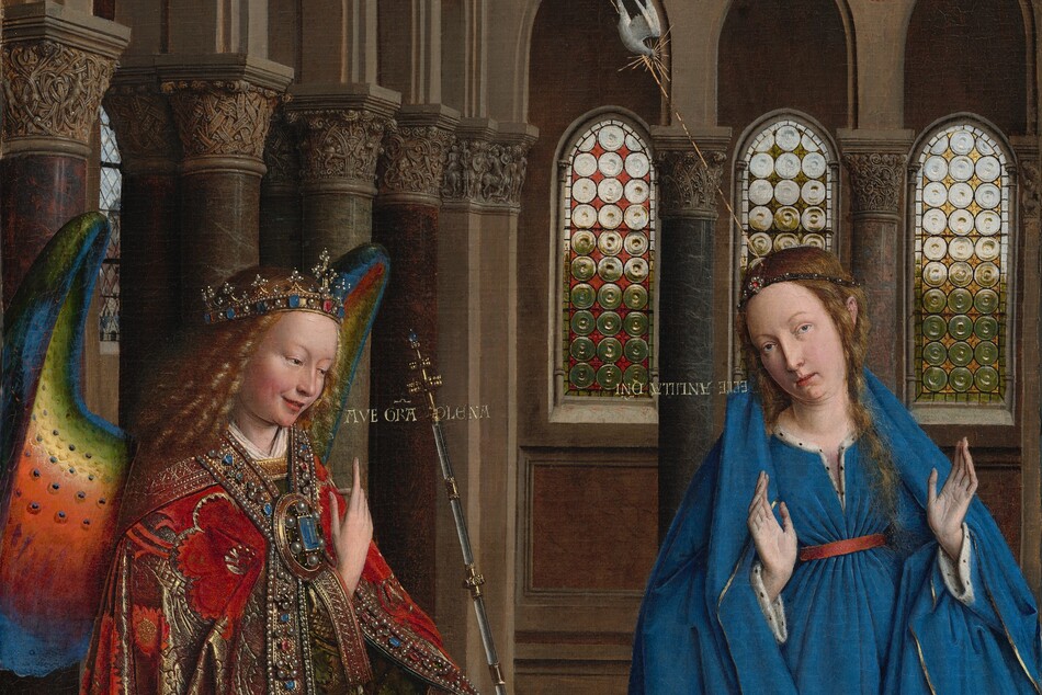 A woman and winged angel, both with pale, peach skin, are situated in a church interior in this tall, narrow painting. To our left, the angel has long, blond, curly hair, smooth skin, and is smiling. The wings are outlined in royal blue, and they blend from blue to green to yellow to crimson. The angel holds one hand, closer to us, up at chest height with the index finger subtly pointing upward. Holding a long scepter in the other hand, the angel angles their body toward the woman to our right. The angel wears a gold jewel and pearl-encrusted crown and a jeweled long, voluminous robe in scarlet-red and shimmering gold brocade. The neck and along the opening down the front are lined with pearls and jewels. The angel looks toward the woman, who wears a royal-blue dress tied with a red belt at the high waist. Her long brown hair is tied back but one tendril falls over her left shoulder, to our right. She kneels facing us with her raised hands facing outward. Her head is tipped a bit to our left, and she looks up and into the distance to our right with lips slightly parted. She kneels behind a book lying open on a low table. A vase of white lilies and a red cushion lies on the floor in front of the table, close to us. The floor is decorated with people and scenes outlined in black and set into square panels, as if inlaid with wood. The church behind and above the people has a row of tall, narrow arches with bull’s-eye glass windows. A walkway lined with columns runs above the arches, and sunlight comes in through arched windows under the flat wood ceiling. A white dove flies toward the woman on gold lines from a window at the upper left of the painting. Latin words painted in gold capital letters are exchanged between the people. The angel says, “AVE GRA PLENA.” The letters of the woman’s response are painted upside down and backward: “ECCE ANCILLA DNI.”