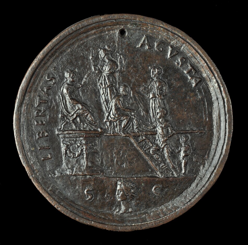 The sculpture is a relief engraving on a circular medal or coin depicting several human figures. The figures are involved in a ceremonial or formal gathering, with some standing and others seated on a raised platform with steps leading up to it. The design includes accompanying inscriptions, with the most prominent reading "LIBERTAS" and "AVGVSTA." The material of the sculpture is a dark metallic bronze, giving it a rich, earthy color with some lighter highlights reflecting off the polished surfaces. The sculpture is divided into two sections, one with figures engaging in a scene and another featuring a smaller, bust-like profile of a face below with the letters “S C” flanking it. The details of the sculpture, although worn, are still discernible, providing an insight into intricate craftsmanship typical of coinage or medal art.