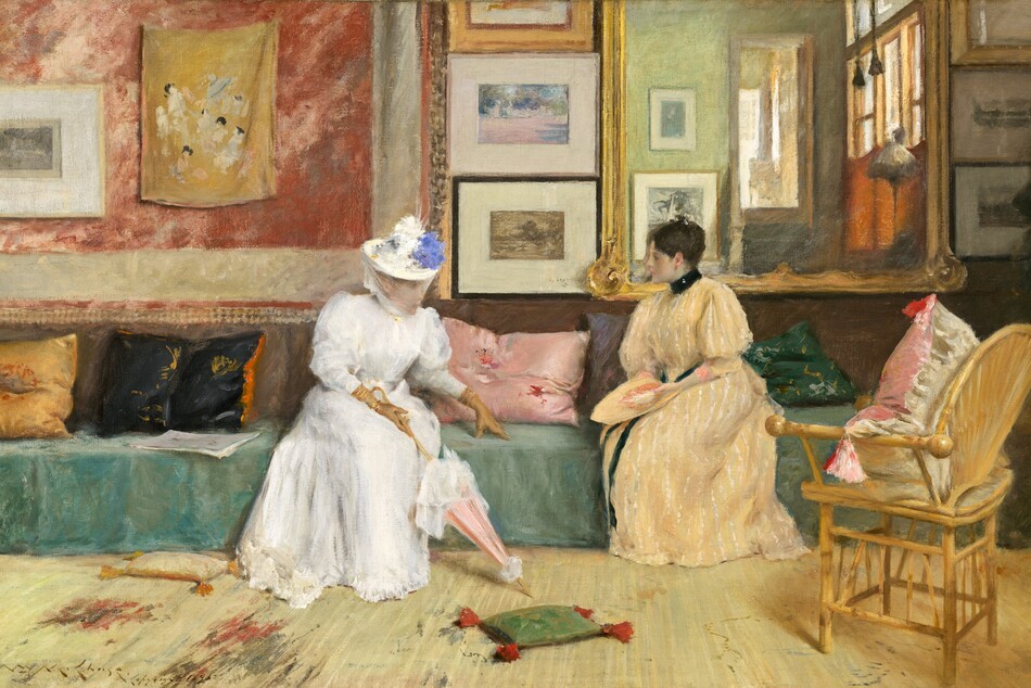 Two pale-skinned women sit facing each other on a long sofa centered on the wall across from us in a room warmly lit from the right in this horizontal painting. The scene is loosely painted so some details are indistinct. The woman on our left wears a white, full-length dress belted at the waist and trimmed with a ruffled hem. The puffy sleeves narrow below the elbow and are tucked into long, fawn-brown gloves. She wears a brimmed hat topped with dabs of white and lapis-blue paint, presumably flowers, with a sheer veil covering her face and chin. Glints of gold at her wrists might be bracelets. Her lower body faces us but her head and torso turn to her left, our right, to face her companion. She leans forward, with her left hand slightly extended, and she rests her fingertips on the cushion between them. Her other hand, closest to us, holds the curving handle of a closed, shell-pink parasol trimmed with white. To our right, the second woman sits with her knees angled to our left as she turns her head in profile, looking at her companion. She wears a floor-length, butter-yellow dress with white, vertical stripes. The dress has a high black collar, and a black ribbon wraps around her waist and falls down the front of the dress. Her sleeves billow at the shoulder and narrow below the elbow. Her dark brown hair is gathered at the top of her head. She holds a flat object in the same butter yellow in her lap that may be a matching hat. The sofa spans almost the entire width of the center of the painting. Its seat is draped in spruce-green fabric, and emerald-green, mauve, rose-pink, black, and gold throw pillows are scattered along its length. The lower half of the wall behind the women is tawny brown while the upper half is divided into four sections. A coral-red and off-white wall hanging fills the wall to our left of the woman in white. A framed artwork and mustard-yellow fabric with daubs of white, ash gray, and black hang on it. Moving right, a column of three framed artworks hang on the wall between the women. Next is a large mirror with a gold frame that hangs behind the woman in yellow. At the far right is another column of three framed artworks. The room behind us is reflected in the large mirror, showing an amber-colored wall with large windows and more framed artworks. Steps leading up to another sunlit room are also visible. A wicker chair with a pink and white pillow sits in the lower right, facing the women at an angle. The floor in front of them fills the lower third of the composition and is covered with a vanilla-yellow carpet streaked with areas of smoke gray and brick red. Two small throw pillows with tassels lie at the feet of the woman in white. The tip of the parasol points to a small sage-green pillow with tomato-red tassels lying on the floor between the women. To our left of the woman in white is a cream-white pillow with marigold-orange tassels. The artist signed and dated the painting in the lower left, “Wm. M. Chase. Copyright 1895.”