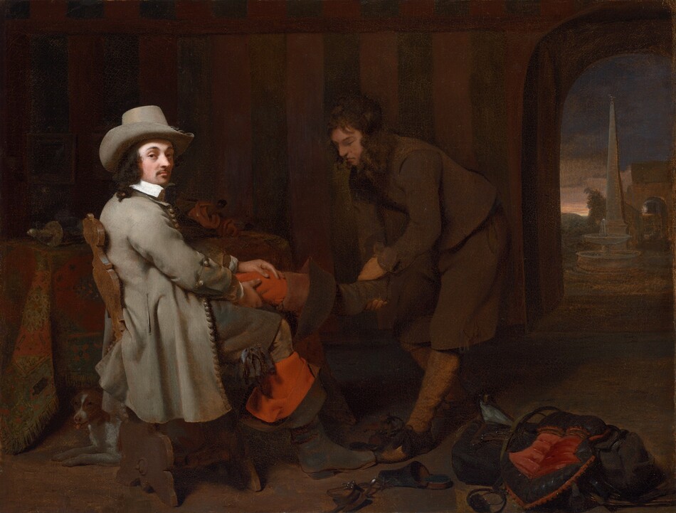 This is a painting of two individuals in a dimly lit room. One person on the left is seated; they are richly dressed in a gray hat and long gray coat, and they look directly toward us. They have pale skin, dark hair, and a dark mustache. They are being assisted by another person on the right who helps them take off their boots. The assistant also appears to have light skin and dark hair, and they wear simple brown clothes. They are in shadow, while the seated person’s face is brightly lit. The dark room features a table with an ornate cloth, a small dog under a chair, scattered shoes, fabric, and an archway showing a glimpse of an exterior scene with a fountain and obelisk against a twilight sky.