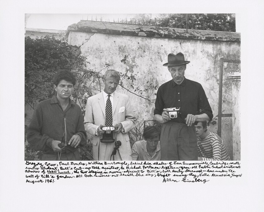 Gregory Corso, Paul Bowles, William Burroughs, behind him shades of Ian Summerville, Cambridge mathematics student, Bill’s cut-up tech assistant, and Michael Portman, eighteen-year-old Public School aristocrat admirer of _Naked Lunch_, the two staying in rooms adjacent to Bill’s, both early deceased — here under the wall of Bill’s garden. All took cameras out beneath blue sky, bright sunny day, Villa Muniria, Tangier August 1961.