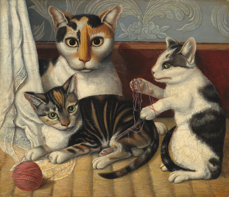 A short-haired calico cat and two kittens lie down or play with a ball of yarn in this horizontal painting. To our left, the largest cat has markings in honey brown and black over its face and along its spine, and the rest of its fur is white. Most of its body disappears behind a lace-trimmed cloth hanging along the left edge of the painting but it lies down so its chest faces us and it looks at us with piercing yellow eyes. One kitten lies in front of the larger cat so all four legs and its tail face us. It has caramel-brown, gray, and black stripes with white patches on its nose, chest, and paws. It looks off to our right with lime-green eyes. To our right, the other kitten rests up on its hind paws so its front paws are free to tangle the end of the carnation-pink yarn, which has rolled off a tidily wound ball to our left, in front of the other kitten. This kitten faces our left in profile and has white fur with flint-gray and black splotches along its spine, tail, and around its ears and eyes. The textured rug beneath the cats is straw yellow. A chestnut-brown baseboard spans the painting behind the cats, and the wall above is slate blue with stylized floral patterns in translucent white. The artist’s precise brushstrokes are especially noticeable in the cats’ fur and their shining whiskers.