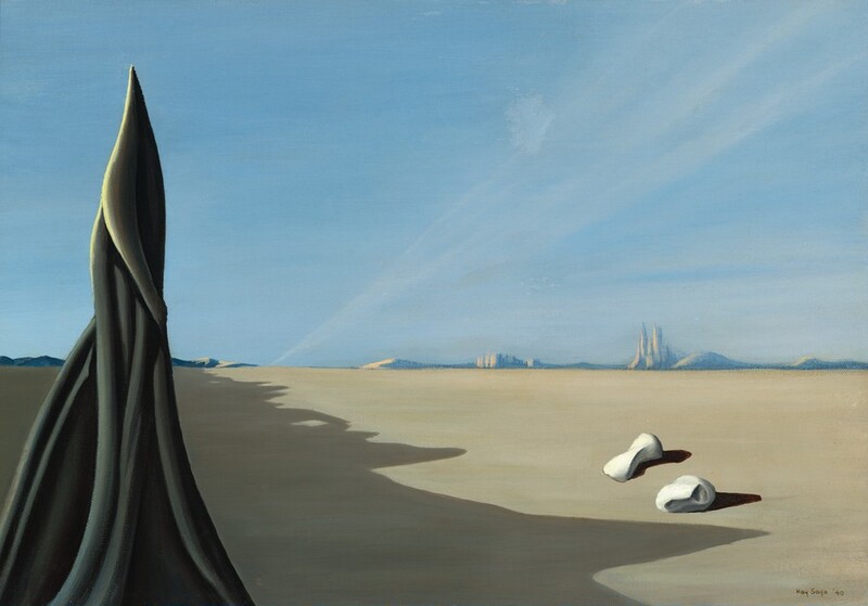 A charcoal-gray, pointed, tower-like form wrapped with cords or vines rises to our left against a barren desert in this horizontal painting. Light falls from our left onto the sharply pointed tip of the tower. A deep, jagged shadow cast from a formation outside of our view to our left falls across the oatmeal-brown desert floor. Two rounded white forms, perhaps stones, lie near the lower right corner, and cast ink-black shadows on the ground. The horizon comes just over a third of the way up the composition. Along the horizon, two clusters of buildings and low hills are painted with tones of hazy indigo blue and tan. The sky above is ice blue, and a veil-like cloud stretches from the horizon to our left of center up into the right corner. The artist signed and dated the painting in the lower right corner, “Kay Sage 40.”