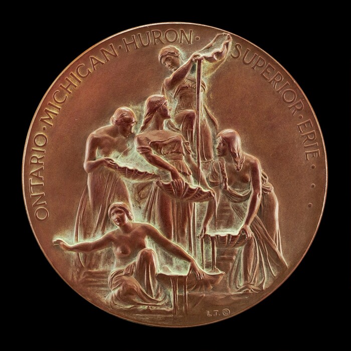 This sculpture is a relief engraving on a circular medal. The scene depicts five female figures engaging in a collaborative activity with a piece of fabric. The figures are draped in classical garments, emphasizing their natural forms. The sculpture is made of bronze-like metal, giving it a rich brown color. Inscriptions naming the Great Lakes - "ONTARIO," "MICHIGAN," "HURON," "SUPERIOR," and "ERIE" - surround the perimeter. The design suggests a connection to the Great Lakes. The sculpture is flat and compact, typical of a medal and meant to be viewed from above.