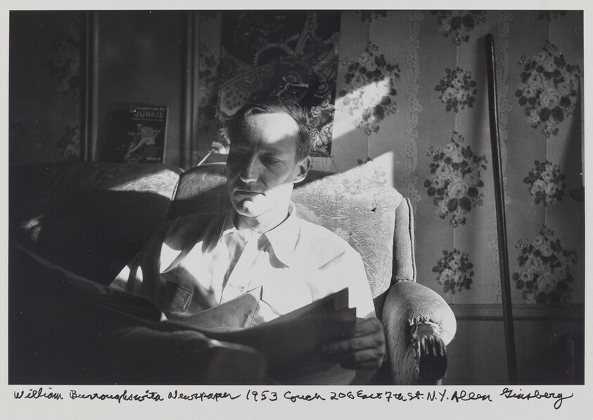 Williams Burroughs with a Newspaper 1953 couch 206 East 7th St. N.Y.