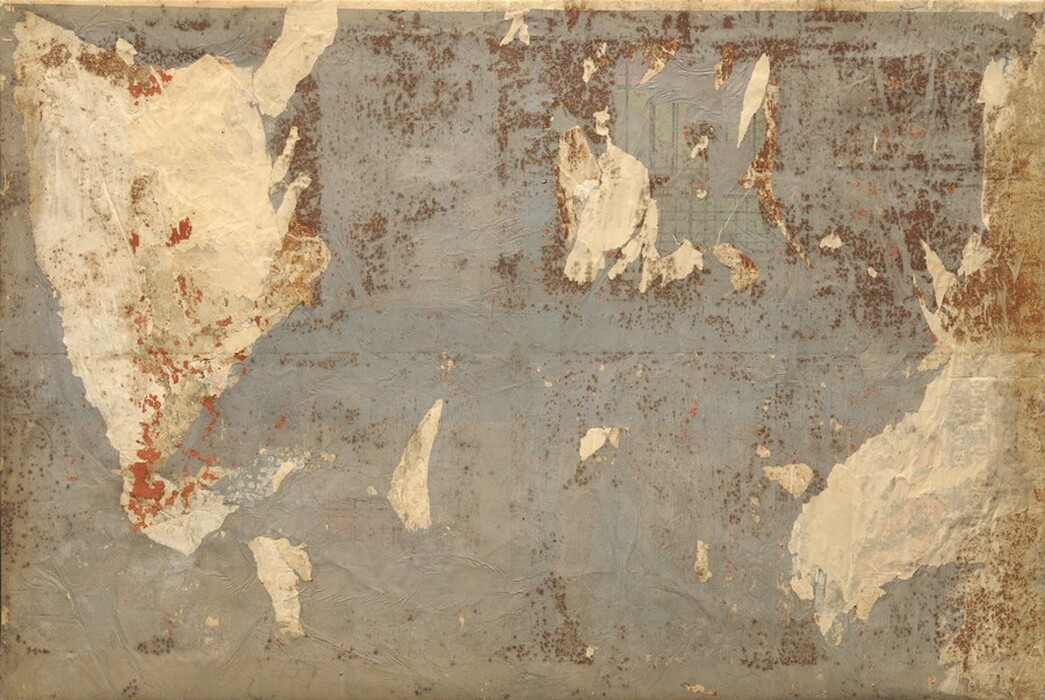 Sheets of cream-white and slate-blue paper are layered and then torn away to create a textured collage peppered with blurry, coffee-brown spots, sometimes densely spaced, and a few speckles and streaks of terracotta red in this rectangular, abstract composition. The artist created this work using a process called decollage, where layers of paper are first adhered to the surface of the canvas and then some are stripped away to reveal the layers beneath. The first impression of this composition could be of an incomplete antique map, especially because the largest white form, to our left, is reminiscent of the shape of North America, and a crease running across the center is like the equator on a map. A strip of off-white paper also lines the right edge of the canvas and about a dozen small, jagged white shapes are spread across the work. In some areas, especially in the upper right quadrant, an under-layer of paper patterned with a grid of dark lines over lime green and raspberry pink shows through one or more layers of paper. The brown dots resemble foxing, as if some of the paper was discolored or stained. Most of the terracotta-red streaks are concentrated on the large shape to our left, but there are spots scattered lightly across much of the composition. Some of the white areas are textured, and could include adhesive or paste, and the blue paper is wrinkled throughout.