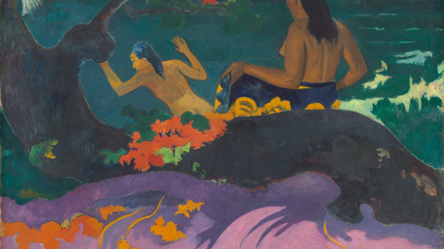 Two nude women with brown skin and long black hair stand with their backs to us at a riverbank in this stylized horizontal painting. The body of the woman to our left is angled to our left with her hands raised, presumably about to plunge into the teal-colored water. The woman to our right unwraps a cloth patterned with bright yellow flowers on a deep purple background from her waist. Between the women and farther away, a bare-chested man, also with brown skin, wears a tomato-red garment across his hips as he stands hip-deep in the water holding a long spear. The top of his head is cropped by the top edge of the painting. Along the left edge of the canvas, a gnarled tree is painted as a flat field of dark, charcoal gray, and it rises off the side and top of the composition. An area of the same color, perhaps a thick root or the trunk growing nearly horizontally, spans the width of the painting, separating the women from us. The area around the trunk to our left and right is painted with fields of evergreen and cool mint. Closer to us, along the front of the root, a field of rosy pink swirls with grape purple to suggest sand. This area is dotted with harvest-yellow and pumpkin-orange vines and stylized flowers. A bunch of vivid orange flowers with pine and spring-green leaves sits on the root near the trunk, to our left. Most of the painting, especially the landscape, is painted with areas of mostly flat color. In the bottom left corner, the artist has written the title of the painting in darkred paint: “Fatata te Miki.” In the lower right corner, he signed and dated the work with periwinkle blue: “P. Gauguin 92.”