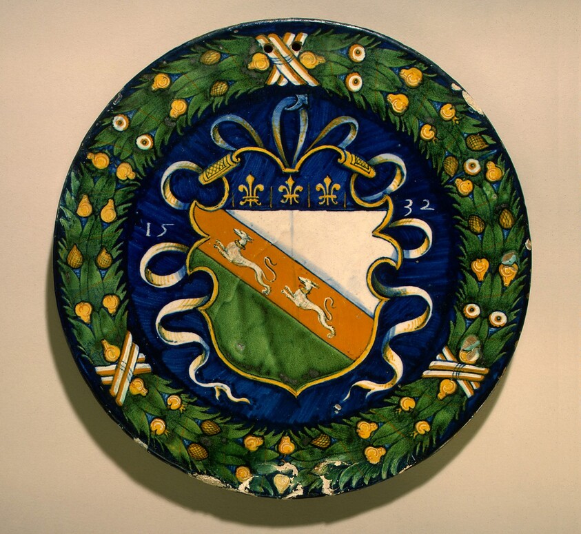 Circular plaque with fruited wreath enclosing a shield of arms