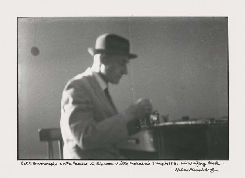 Bill Burroughs with camera in his room Villa Muniria Tangier 1961. His writing desk.
