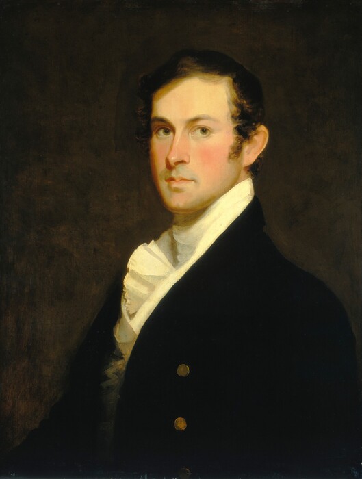 The image shows the upper half of a man's body in a formal, seated pose. He is facing slightly to his right, with his head turned towards the viewer. The man has short, dark brown hair, a smooth complexion, well-defined eyebrows, and a serious expression. He is dressed in a dark jacket with gold buttons, over a high-collared white shirt with a ruffled front. The background is a dark, neutral color.
