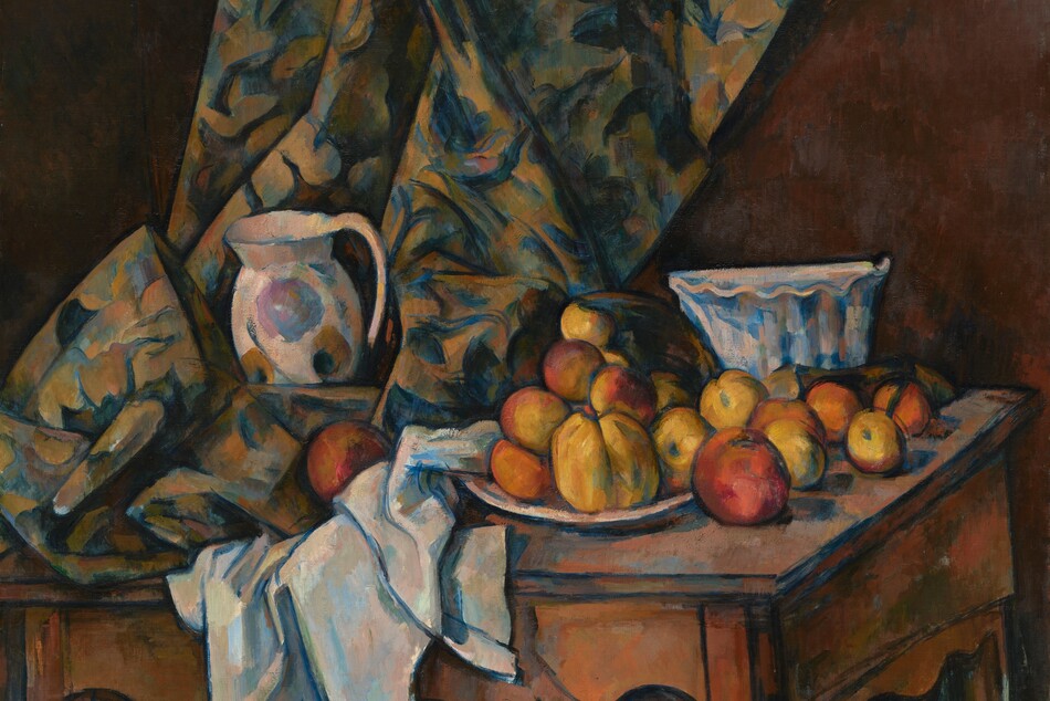 About a dozen rust-orange and golden yellow apples and peaches are arranged on a white plate next to white and floral-patterned cloths nestled around a white pitcher and bowl, all on a wood tabletop that tilts toward us in this nearly square still life painting. A curtain patterned with royal blue, olive green, and beige falls along or near the back wall of the room and rests on the table to our left. The white pitcher is painted loosely with the suggestion of harvest-gold and pale lilac-purple flowers, and it sits amid the pooling folds of the curtain to our left. The white tablecloth is bunched under and next to it to our right, at the middle of the composition. The fruit is arranged on and around a white plate next to the tablecloth. A tall bowl with fluted sides and a ruffled, scalloped rim sits behind the fruit, near the right edge of the table. The curving skirt of the table reaches nearly to the bottom edge of the canvas. All the objects in the painting are outlined with dark blue and the shadows are painted with patches of spruce and cobalt blue.