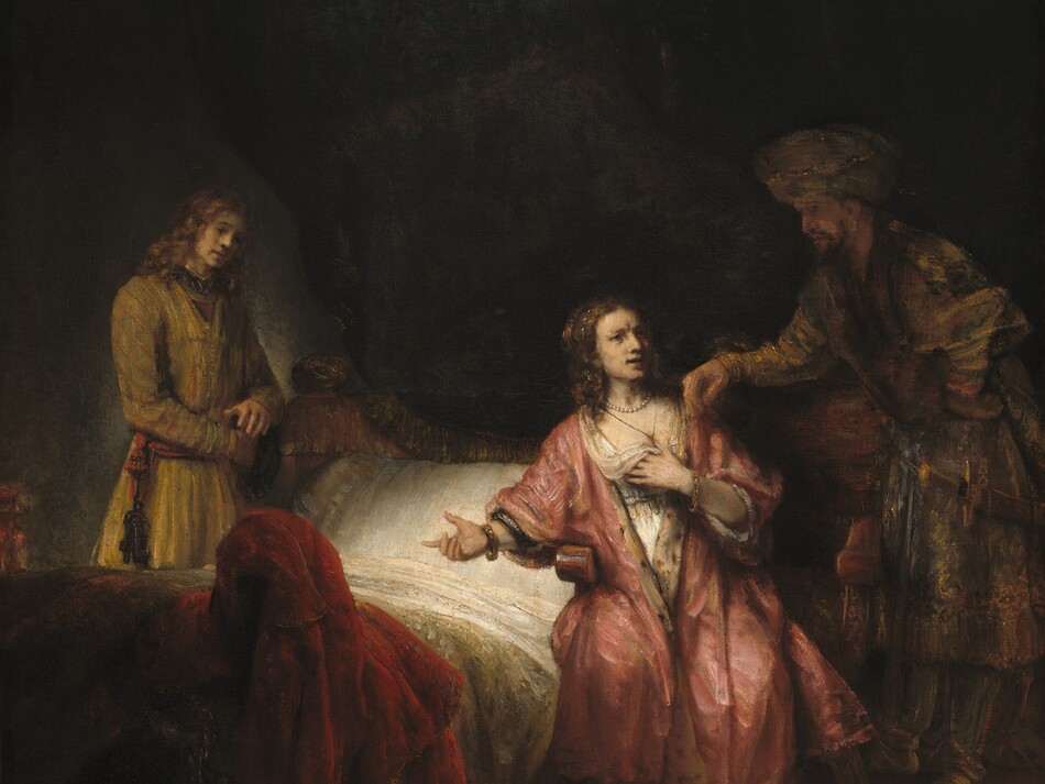 A pale-skinned woman sits in a pool of light against a deeply shadowed background in the bottom half of this vertical painting. She sits in the center of the composition, in a heavy wooden armchair next to a bed, which is flanked by two men. The woman wears a rose-pink, fur-trimmed robe draped over a white chemise. A pearl necklace and gold bracelets gleam at her throat and wrists, and her chestnut-brown hair is partially pulled up while curls fall to her shoulders. She looks to her left, our right, at a shadowy bearded man. He wears a turban wrapped in a gold chain, a cloak patterned with shades of bronze, olive green, and rust red, and a sword hangs from his belt. He stands facing our left, stooping slightly to rest his right arm, farther from us, on her chair, and his hand brushes her shoulder. The woman's mouth is open and brow furrowed as she points to the bed with her right hand, to our left. Her other hand holds up the loose neckline of her chemise to cover her chest. The bed is angled slightly away from us, to our left. It is covered with white linens and a mustard-yellow coverlet. A burgundy-red cloth or garment is draped over a bedpost at the foot of the bed. A younger man stands on the far side of the bed with his body angled to our right. He wears an olive-green tunic. A broad, scarlet-red sash is tied around his waist, and a bunch of keys hangs from it. Shoulder-length, light brown hair frames his face. His head tilts slightly to our right, and his hands are clasped at the waist, holding what looks like a black cap. A faint light him behind him creates a soft halo around his body. The top half of the painting is swallowed in deep shadow. The artist signed and dated the painting in the lower right, “Rembrandt. f. 1655.”