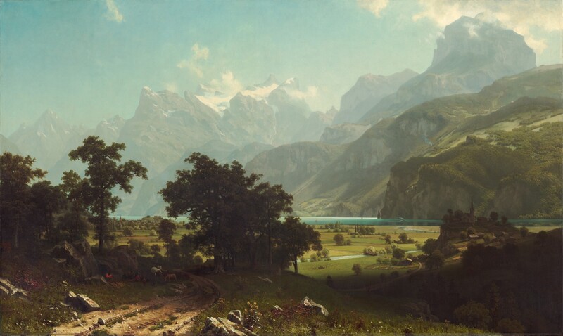 From a little above a dirt road, we look past a grove of trees to a broad plain and a lake at the foot of towering, hazy mountains in this horizontal landscape painting. The narrow, teal-blue lake runs from left to right along the horizon, which comes about a third of the way up the composition so the hills and mountains take up most of the picture. On the far shore of the lake, steep hills are thick with fern-green trees and growth. Beyond these hills, muted gray and green rocky mountains reach precipitously into the clear, robin’s egg-blue sky so some nearly touch the top edge of the canvas. Snow nestles in the mountain peaks while gauzy mist hovers among the mountain tops. The meadow below is a patchwork of avocado-green and sand-brown fields. An ice-blue stream winds from the lake across the plain while olive-green trees and shrubs dot the fields. Closest to us, in the lower left corner of the painting, small stones and clumps of green grass run along the dirt road, and boulders line it to either side. A band of dark green spanning the road creates a screen a short distance from us, in the lower left quadrant of the composition. Through the trees is a view of minuscule buildings lining the lakeside. In the shadows, under the trees, people camp with a covered wagon covered in white fabric and several animals including a donkey. A red and yellow fire glows, almost lost in the deep shadows of the trees, next to the people. On our right, about a dozen people with a horse-drawn wagon, all tiny in scale, work in the field next to the stream. Farther along the stream, another wagon approaches a covered bridge. On our right and close to us, a dark shadow falls across the landscape. Beyond the shadow, a group of buildings with a church in the center sit on a low hill.