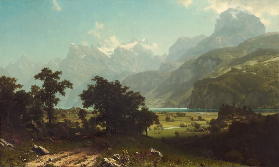 From a little above a dirt road, we look past a grove of trees to a broad plain and a lake at the foot of towering, hazy mountains in this horizontal landscape painting. The narrow, teal-blue lake runs from left to right along the horizon, which comes about a third of the way up the composition so the hills and mountains take up most of the picture. On the far shore of the lake, steep hills are thick with fern-green trees and growth. Beyond these hills, muted gray and green rocky mountains reach precipitously into the clear, robin’s egg-blue sky so some nearly touch the top edge of the canvas. Snow nestles in the mountain peaks while gauzy mist hovers among the mountain tops. The meadow below is a patchwork of avocado-green and sand-brown fields. An ice-blue stream winds from the lake across the plain while olive-green trees and shrubs dot the fields. Closest to us, in the lower left corner of the painting, small stones and clumps of green grass run along the dirt road, and boulders line it to either side. A band of dark green spanning the road creates a screen a short distance from us, in the lower left quadrant of the composition. Through the trees is a view of minuscule buildings lining the lakeside. In the shadows, under the trees, people camp with a covered wagon covered in white fabric and several animals including a donkey. A red and yellow fire glows, almost lost in the deep shadows of the trees, next to the people. On our right, about a dozen people with a horse-drawn wagon, all tiny in scale, work in the field next to the stream. Farther along the stream, another wagon approaches a covered bridge. On our right and close to us, a dark shadow falls across the landscape. Beyond the shadow, a group of buildings with a church in the center sit on a low hill.