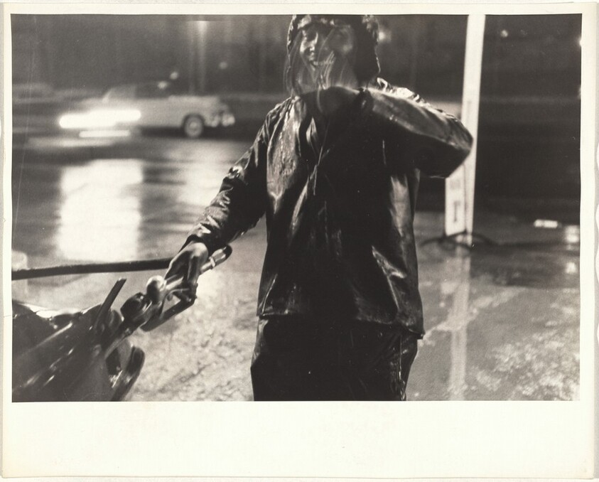 Man pumping gas in rain--San Francisco