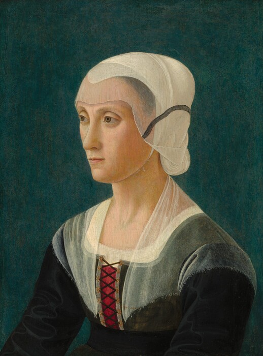 Shown from the chest up against a dark, teal-blue background, a light-skinned woman looks off to our left left in this vertical portrait painting. Her arms extend slightly in front of her, as if they rest on her knee. Her face turns almost in profile to our left as she gazes in that direction with hooded light brown eyes under curved brows. She has a sloping nose, a pointed chin, and her thin, light pink lips are closed. A white covering over her hair, which has been pulled back and up, is layered under a translucent ivory-white veil that covers her forehead and the sides of her face. A charcoal-gray stripe on the veil creates a line from her cheek to the back of her head. Her dress has a black bodice and sleeves, and the chest and the tops of her shoulders are covered with another veil. A patch of burgundy red shows through where the dress is laced up over the chest.