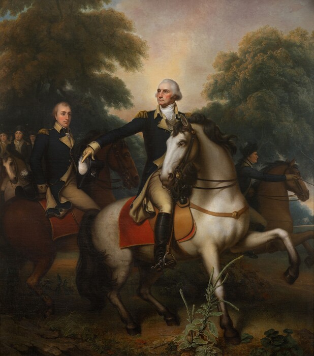 A man wearing a military uniform and riding a horse gestures in front of a small band of soldiers in this vertical painting. All the men have pale skin and wear navy-blue and flax-yellow uniforms. The central man, George Washington, and the cream-white horse he rides take up most of the composition. The horse has a glossy black mane and tail, and black hooves. The horse stands with its body facing our right in profile, one front leg lifted, but it turns its head to look off to our left with clear brown eyes. There is a scarlet-red blanket under the fawn-brown saddle. Washington also turns his head to our left to look up and off in that direction. He has a high forehead, a beaked nose, and his thin pink lips are pressed in a line. He has ruddy cheeks, a dimpled chin, and jowls along his jawline. His white hair is streaked with gray, and it sweeps back from his high forehead and bushes out over each ear. His blue jacket has gold epaulets, a high yellow collar around a white neckerchief, and gold-colored buttons down the front. The uniform also has yellow lapels, cuffs, and knee-high britches. The toe of his knee-high black boots pushes against the horse’s stirrup. Washington holds his right arm, to our left, out and points down with a gloved hand, which also holds a black, tricorn hat. The nearest man, just behind Washington to our left, rides a chestnut-brown horse. He is cleanshaven with blond hair, and looks at Washington, one hand tucked behind his lower back, where his hat rests on the horse’s rump. Several more men ride together under a grove of trees to our left, and the final rider lurches forward on a horse whose two front legs are raised midstride, to our right of Washington. The dirt ground beneath has some scrubby grass and a few plants. Tall, leafy green trees stretch to the sky to either side of the painting. The artist signed the painting in the lower left corner, on a rock. It reads, “Remt. Peale.”