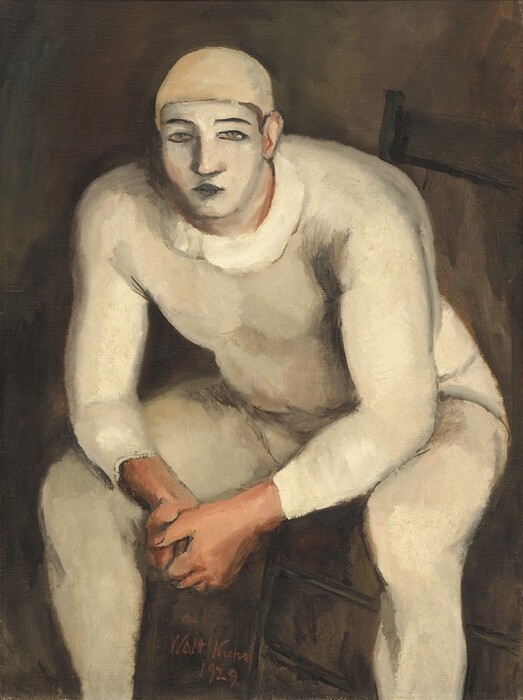 A stocky, muscular man with his face painted white and wearing a skin-tight, oyster-white costume sits on a wooden chair, leaning forward toward us with his elbows resting on his knees in this vertical painting. The man nearly fills the canvas, and his feet are cropped by the bottom edge. His body is angled slightly to our left with his knees spread wide, but he looks out at us. He wears a pale, beige-colored cap and his cream-white bodysuit may have a loosely painted, wide collar. His nearly straight eyebrows and closed lips are painted black, and his narrow gray eyes are outlined in black, against the white oval of his painted face. His clasped hands, ears, and his skin visible along the edges of his makeup are pale peach. The background is earth brown. The artist signed and dated the work with red paint between one of the man’s legs and the leg of the chair, near the lower center: “Walt Kuhn 1929.”