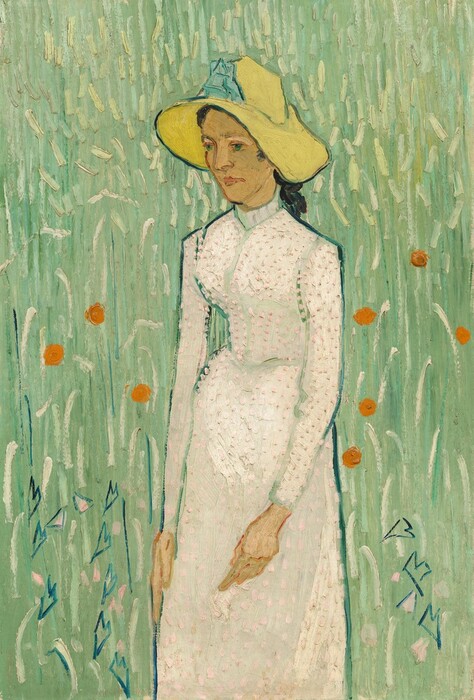 Shown from the knees up, a pale-skinned woman wearing a floppy, canary-yellow hat and a long white dress stands in a field of spring green in this vertical painting. Brushstrokes and loose dabs of paint are visible throughout. The woman’s body is angled to our left, and she looks off in that direction with bright green eyes. Her nose, eyebrows, and narrow chin are outlined with medium brown, and her pink lips are closed. Her black hair is pulled back under the hat, the wide brim of which droops down either side of her face. A sky-blue ribbon or decoration is on the front of the crown. Her dress has a high collar, a fitted bodice, long sleeves, and a long skirt. Pale pink daubs on the white dress are thickly applied so the texture of the paint can be seen on the surface of the canvas. The background is painted with long and short curved dashes of celery green layered over laurel and cool green. Several tangerine-orange dots, a few shell-pink dabs, and some angular, heart-shaped forms in cobalt blue to each side of the woman suggest flowers.