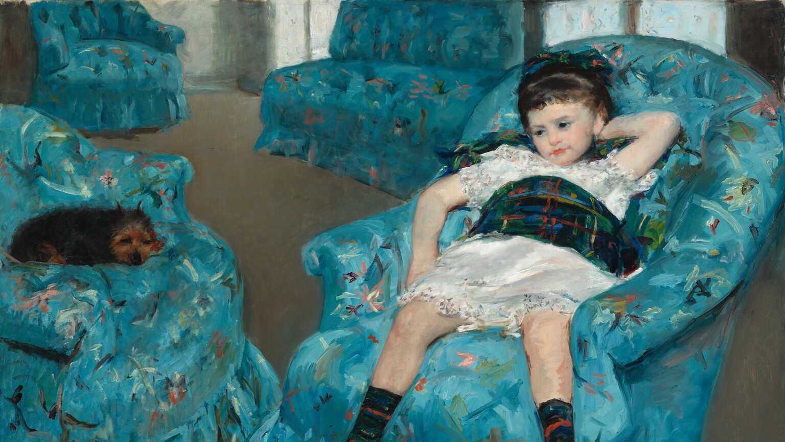A small brown dog and a pale-skinned little girl wearing a white dress sit in matching celestial-blue armchairs in this horizontal painting. To our right, the girl sits with her legs angled to our left. She slumps back with her legs spread, and her left elbow, on our right, is bent so that hand rests behind her head. Her other elbow is draped over the armrest. Her dark brown hair appears to be pulled back, and tawny brown eyes under faint brows gaze down and to our left. She has a small nose set in a round face and a coral-pink mouth closed in a straight line. Her white dress has touches of gray, soft pink, and powder blue with a wide plaid sash around her waist. The pine-green, black, and sapphire-blue sash is accented with overlapping vertical and horizontal lines of burnt orange, light blue, and mustard yellow. Her socks match her sash and come up to mid-calf, over black shoes with silver buckles. The small dog has scruffy black fur and a russet-brown face. It lies curled in the chair opposite the girl, to our left, with its eyes closed and ears pricked up. The rounded backs of the upholstered chairs curve down to become the low arms. The vivid and light blue fabric of the chairs is scattered with loosely painted strokes of avocado and forest green, peach pink, cherry red, plum purple, and white. Beyond the chairs closest to us is another armchair and an armless loveseat, both covered with the same fabric. They sit at the back of the room, in a corner flooded with silvery light coming through four windows on the right side. The furniture is arranged on a peanut-brown floor. The artist signed in the lower left, “Mary Cassatt.”
