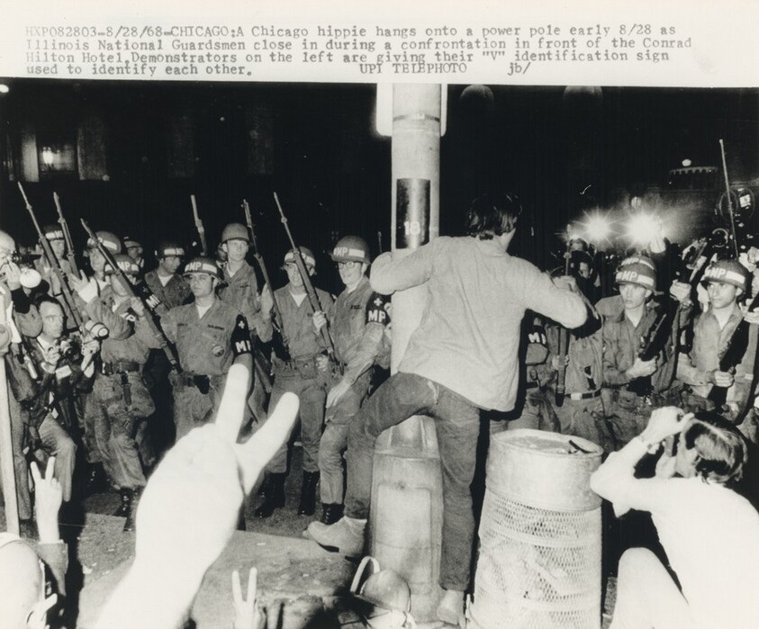 Title from caption on object: “A Chicago Hippie Hangs onto a Power Pole...”
