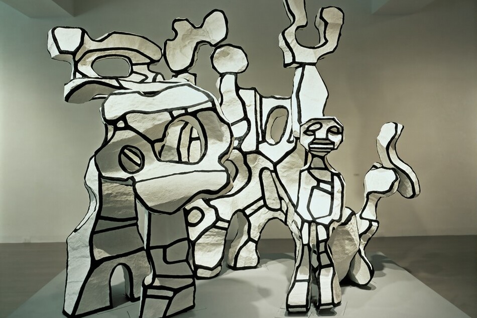 Abstract forms turn, twist, and curve up around a person with cartoon-like features in this free-standing sculptural piece.