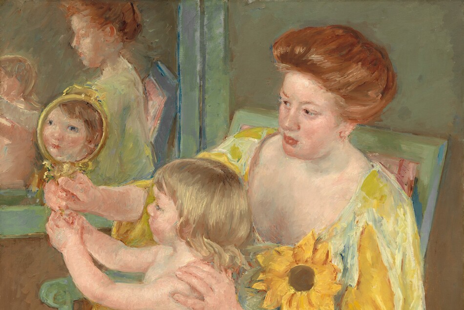 We look slightly down onto a woman dressed in golden yellows, sitting in a pale green chair, with a nude child sitting in her lap as they both gaze into a mirror in this vertical portrait painting. Both the people have pale, peachy skin. The chair is angled to our left so the woman’s knees and child cant down toward the lower left corner of the composition, and the woman leans onto the arm closer to us. The chair is painted mint green and the rose-pink upholstery is visible on the seat and a corner behind the woman’s shoulder. To our right, the woman’s vibrant, copper-colored hair is pulled loosely to the back of her head. She has a rounded nose, flushed cheeks, and her full, coral-pink lips are closed. Her long dress has a low, U-shaped neckline. The fabric shimmers from pale, cucumber green to light sunshine yellow. The sleeves of the dress split over the shoulder and a second long, goldenrod-yellow sleeve falls from her elbow off the bottom edge of the canvas. An oversized sunflower, larger than the woman’s face, is affixed to her dress near her left shoulder, closer to us. She looks with dark eyes down toward the small, gold-rimmed mirror she holds in her right hand, farther from us. The child also holds the handle of the mirror with both hands, and in the reflection, the child looks back at us with dark eyes, a button nose, and pink lips. The child’s hair in the reflection is the same copper color as the woman’s, but the child on her lap has blond, shoulder-length hair. The woman rests one hand on the child’s left shoulder, closer to us. The child has a rounded belly and smooth, rosy limbs. The woman and child are reflected in a second mirror hanging on the wall alongside them, opposite us. Their reflections are very loosely painted. The wall behind the pair is sage green across the top and it shifts to fawn brown across the bottom. Brushstrokes are visible throughout, especially in the woman’s dress and hair, and are more blended in the bodies and faces. The artist signed the painting in the lower right corner, “Mary Cassatt.”