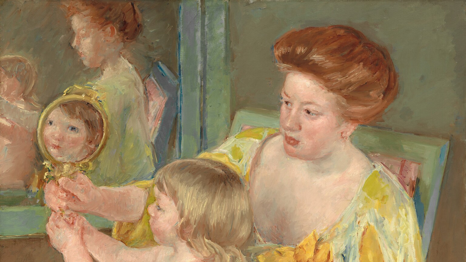 We look slightly down onto a woman dressed in golden yellows, sitting in a pale green chair, with a nude child sitting in her lap as they both gaze into a mirror in this vertical portrait painting. Both the people have pale, peachy skin. The chair is angled to our left so the woman’s knees and child cant down toward the lower left corner of the composition, and the woman leans onto the arm closer to us. The chair is painted mint green and the rose-pink upholstery is visible on the seat and a corner behind the woman’s shoulder. To our right, the woman’s vibrant, copper-colored hair is pulled loosely to the back of her head. She has a rounded nose, flushed cheeks, and her full, coral-pink lips are closed. Her long dress has a low, U-shaped neckline. The fabric shimmers from pale, cucumber green to light sunshine yellow. The sleeves of the dress split over the shoulder and a second long, goldenrod-yellow sleeve falls from her elbow off the bottom edge of the canvas. An oversized sunflower, larger than the woman’s face, is affixed to her dress near her left shoulder, closer to us. She looks with dark eyes down toward the small, gold-rimmed mirror she holds in her right hand, farther from us. The child also holds the handle of the mirror with both hands, and in the reflection, the child looks back at us with dark eyes, a button nose, and pink lips. The child’s hair in the reflection is the same copper color as the woman’s, but the child on her lap has blond, shoulder-length hair. The woman rests one hand on the child’s left shoulder, closer to us. The child has a rounded belly and smooth, rosy limbs. The woman and child are reflected in a second mirror hanging on the wall alongside them, opposite us. Their reflections are very loosely painted. The wall behind the pair is sage green across the top and it shifts to fawn brown across the bottom. Brushstrokes are visible throughout, especially in the woman’s dress and hair, and are more blended in the bodies and faces. The artist signed the painting in the lower right corner, “Mary Cassatt.”