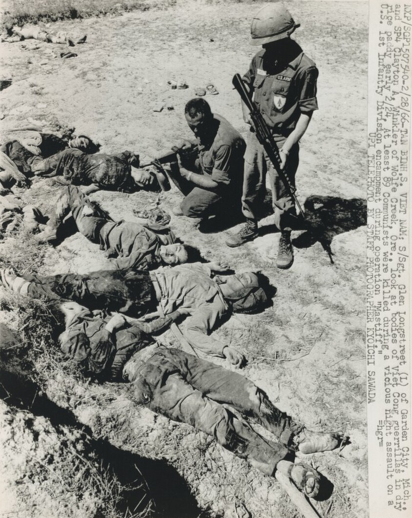 Title from caption on object: “Sargent Glen Longstreet of Garden City, Michigan and SP4 Clayton A. Winkler of Wolfe Creek, Oregon Look at Bodies of Viet Cong Guerilla...”