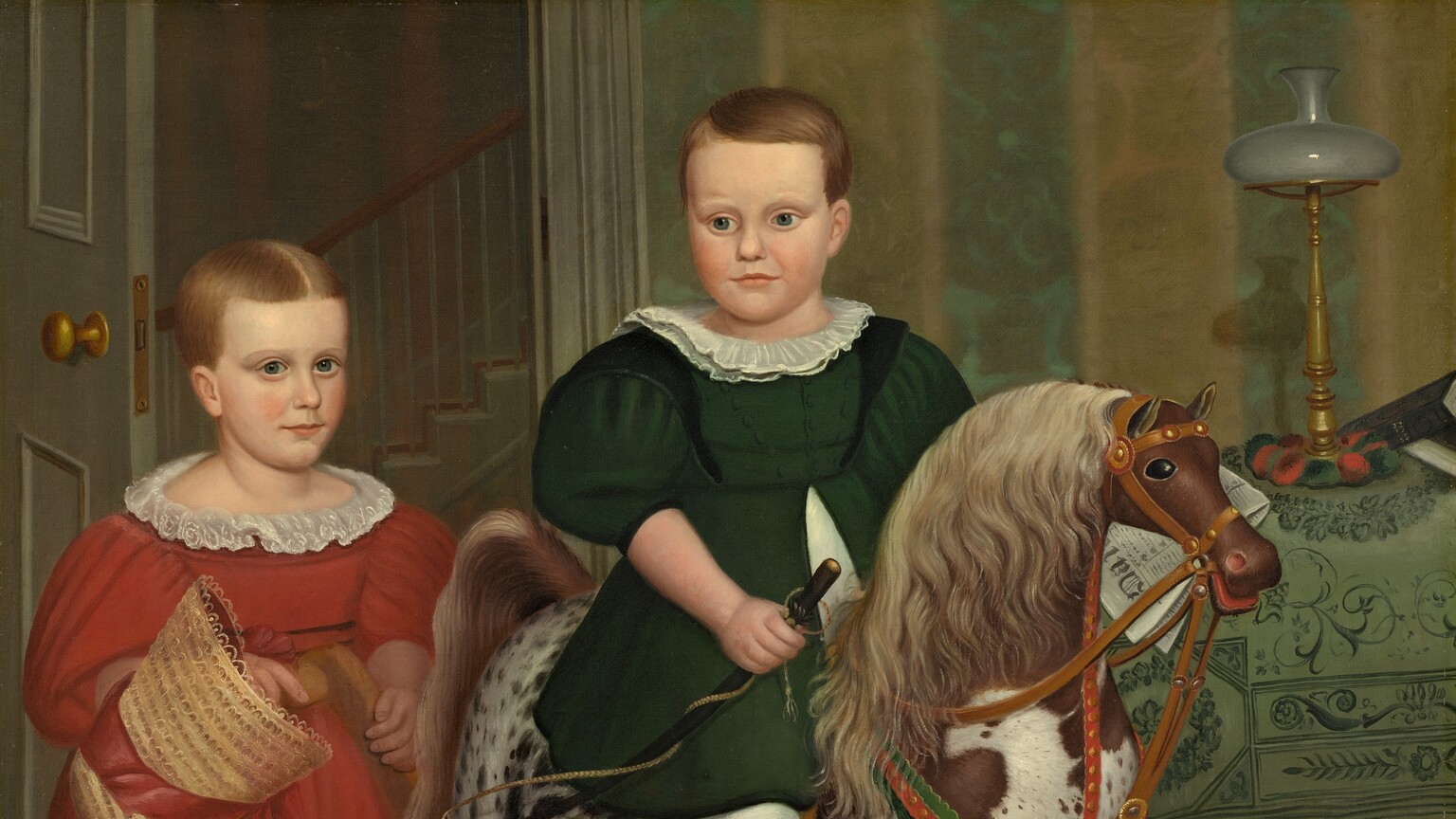 Two children with pale, peachy skin stand and sit on a rocking horse in a wallpapered interior in this square painting. Both children have short, honey-brown hair, high foreheads, dark blue eyes, and small, rounded noses. Their cheeks are smooth and the corners of their thin, pale pink lips curl slightly up. Both wear dresses with puffy, elbow-length sleeves, white collars, calf-length skirts, and wide, white pantaloons over white stockings. At the center of the composition, one child sits astride the rocking horse, which faces our right in profile. The skirt of the forest-green dress splits at the waist to fall open on either side of a white garment underneath. That child’s head turns back over one shoulder to look down and to our left. One black shoe rests in a stirrup, and the child holds a riding crop in one hand. The horse is dappled with fawn brown and white, and has a parchment-brown mane and tail. The horse’s eye we can see is black and its red mouth is open around the bridle and reins. The second child stands at the back of the rocking horse, hands resting on the crossbar that connects the toy's long, curving rockers. That child wears a crimson-red dress and holds the red ribbon of a straw bonnet in one hand. The hair is parted down the middle and that child looks at us. A black cap with a curved, shiny visor and tassels hanging from the crown rests on the base of the rocking horse. The rug has a stylized, terracotta-orange floral pattern against a pine-green background. The wall behind the children is striped with wide bands of golden yellow and moss green. A door with a gold-colored doorknob is swung inward to our left, behind the child in red, to reveal the profile of a staircase beyond. To our right, just behind the horse’s head, a wooden table is draped with a cloth patterned with vines and leaves in dark green against a pea-green background. A lamp with a tall, spindly brass base is topped with a squat, round white globe. A folded newspaper behind the child in green could rest on the table, or could be held by that child. An inscription on the masthead of the paper begins, “Dai.”
