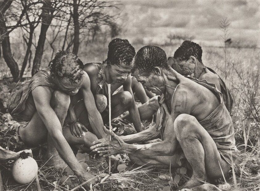 The San people make a fire by twirling a stick against a piece of hardwood, held in place by a foot or hand. Botswana.