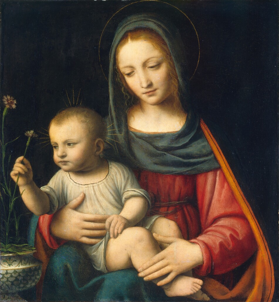 Shown from the lap up, a young woman sits facing us as she cradles a plump baby in her lap in this square painting. They both have pale, peachy skin and blond hair. They are softly lit from the upper left, and the background behind them is inky black. A sea-blue cloth drapes over the woman’s head and across her shoulders. Its top edge is rolled back slightly, revealing tendrils of long, wavy hair framing her face. A thin gold line creates a delicate halo around head. Her scarlet-red gown is gathered and belted high above the waist. A cobalt-blue mantle lined with pumpkin orange drapes down over her shoulders, the arm of her chair, and her lap. She tilts her head slightly to our left, and lowers her eyes to gaze at or toward the child. She holds his torso with her right hand, to our left, and rests her other hand across his ankles. The child wears a dove-gray tunic with rolled up sleeves. His short hair lies in flat swirls, and his chubby cheeks are tinged with pale pink. Clusters of short gold rays fan out from the top and sides of his head. He fingers the hem of his tunic with his left hand as he turns his upper body to his right, our left, to pluck a carnation with tan, spiky petals on a long, thin green stem with his other. This carnation and at least one other with a wine-red center is held in a wide, squat, cream-white vase decorated with fern-green scallops and leaves.
