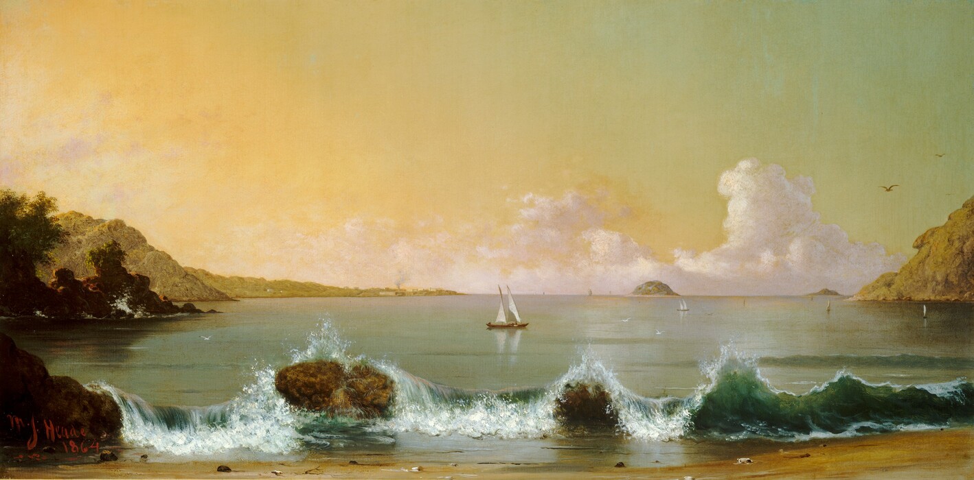 Across a short stretch of sand in front of us, waves of bottle-green water break over two boulders on the shoreline, with sailboats in the water beyond, in this wide, horizontal painting. One boulder is at the left edge of the painting; the other is a short distance away, about a quarter of the way across. The water cascades down between those large rocks. Across the rest of the beach, the waves flare up to break toward us in white, foamy surf. The land curves back into view on both sides of the canvas with muted, sage-green hills and, to our left, dark green trees on more craggy boulders. A more distant finger of land to our left stretches nearly halfway across the horizon, which comes about halfway up the composition. Minuscule in scale there, smoke pours out of a chimney, which is surrounded by pale yellow buildings. A mound emerges from the horizon to our right of center. About ten sailboats float on the water. The closest one to us is near the center of the painting, and the tiny forms of people aboard can just barely be made out. The other boats become smaller as they move back to the horizon, and some are only a touch of white or gray on the canvas. White and pale lavender-purple clouds sweep up from the horizon into the sky, which glows butter yellow along the left edge. The sky cools to mint green in the upper right corner. Several white or brown birds fly across the sky or low over the water. The artist signed and dated the lower left, “M. J. Heade 1864.”