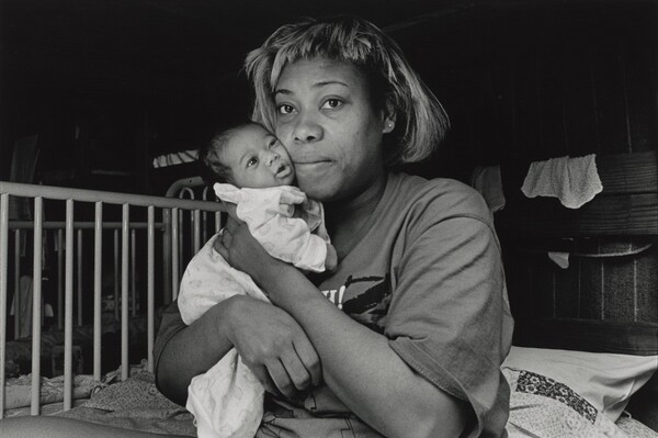 It's 3:00 a.m. No way to sleep. Imaginary bedbugs chewing at me. The air is oppressive, like being buried alive. The cries of asthmatic children sniffling, screaming, sleep-talking keeps me on edge. In semi-darkness I wander among the beds, seeing mothers wrapped around their babies, like bears in hibernation. In one lower bunk, I find an exhausted mother, Pam, rocking her wailing week-old daughter. Pams face glows with inner peace. She is one of the lucky ones. She escaped an abusive relationship and found shelter here. Olive Branch Mission, Chicago.