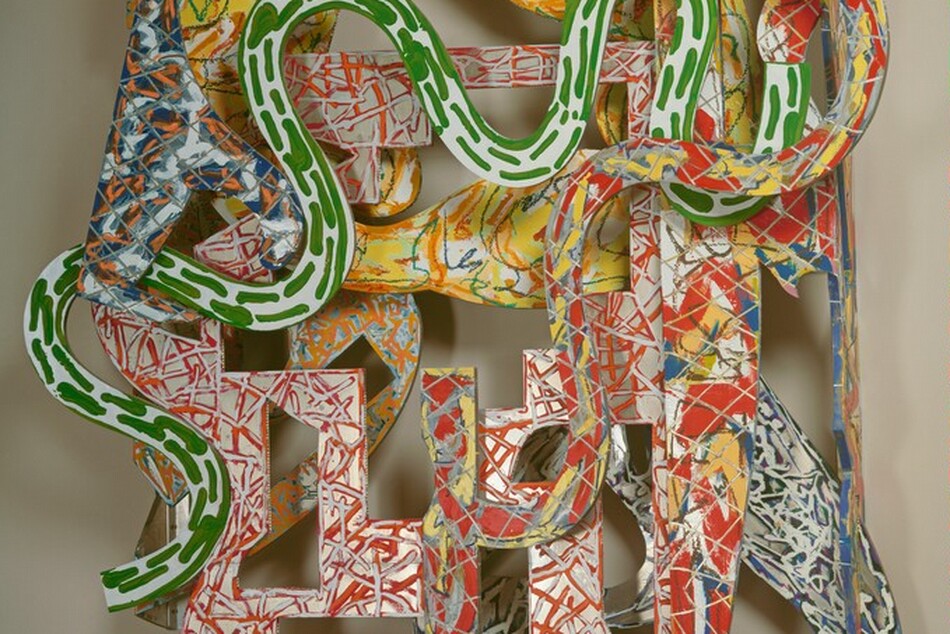 Snake-like and geometric shapes covered with energetic patterns of vivid red, yellow, green, blue, and orange are layered to form this abstract, roughly oval sculpture, which hangs on a wall. The shapes have oval, rectangular, L-shaped, and square openings cut into them, and their patterns are created with scribbles, squiggles, dashes, and blobs of color like canary yellow, tomato red, lime green, cobalt blue, and white. The frontmost layer has undulating curves in kelly green on white. Other layers have red and yellow marks against gray, red and silver against white, and blue and silver. A tall rectangle on the right side extends slightly above and below the oval form of the rest of the sculpture.