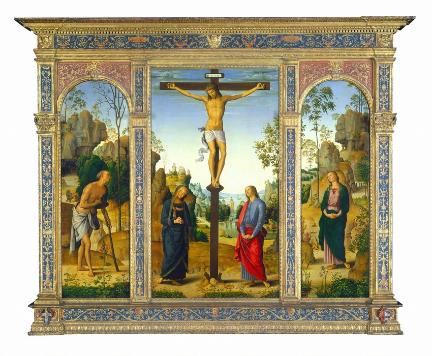 One tall, rectangular panel is flanked by arched panels to each side, all set within a carved, painted, gilded wooden frame. The central panel shows two people at the foot of a wooden cross, to which a man is nailed, and the panels to each side are each occupied by a single person. All the people have pale skin and are shown against landscapes with rocky outcroppings along a river that extends into the deep distance. At the center of the middle panel, the man hangs from the cross from nails in his hands and one nail driven through his overlapping feet. He is nude except for the white loincloth wrapped around his hips, which falls in fluttering ripples alongside his right leg, on our left. Blood drips down his forehead from where a ring of thorns encircles his shoulder-length, chestnut-brown hair. His head tilts to his right, our left, and his eyes are closed or downcast. Blood also drips from his hands and feet, and from a slit over his right ribcage. The woman standing to our left of the cross wears a navy-blue robe edged in gold that covers her head and drapes to her ankles above bare feet. Her head tips down to our right, and she holds her hands clasped loosely, fingers intertwined, at her waist. The person standing to our right of the cross wears a cobalt-blue robe under a vivid, scarlet-red cloak. He has blond curly hair and delicate features, like the woman. With arms nearly straight, he holds his interlaced fingers with palms facing down, close to his body. He looks up at the man on the cross. Low hills dotted with flowers and plants separate the people from a river that runs between rocky hills and outcroppings. Stone buildings line the bank beyond a bridge spanning the river in the distance, and three boats sail near the horizon line, which comes halfway up the composition. The hills and mountains look green and then blue in the deep distance under a sky that fades from nearly white along the horizon to pale, topaz blue along the top edge of the panel, which is also lined with clouds. In the panel to our left, a balding man with gray hair leans on a wooden staff like a crutch, nearly in profile facing our right. He also is nude aside from a slate-gray cloth that wraps around his hips. He holds his loosely fisted right hand up to his chest. A lion stands in front of a cave entrance behind the man. In the panel to our right, a woman wears a mauve-pink dress under a pine-green cloak. She holds her hands clasped with fingers interlaced at her abdomen. A small, gold-colored jar with handles sits on a rock to our left. Both the man and woman in the side panels look up toward the man on the cross. The landscape behind those in the side panels enclose each scene with rocky outcroppings that seem closer to us than the landscape in the central panel. More plants and flowers, and also trees, dot each landscape and soften the caramel-brown boulders with touches of moss and emerald green. The frame encasing the panels is carved and gilded gold around strips of aquamarine blue, which are painted with swirling tendrils, vines, urns, shells, animals, and some mask-like faces.