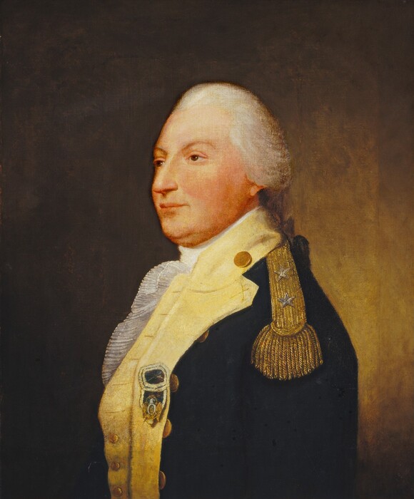A pale-skinned man wearing a military uniform is shown from the waist up in this vertical portrait painting. His body is angled to our left with his arms by his sides, and he looks in that direction with brown eyes under curving brows. He has a straight, pointed nose, slightly pursed pink lips, and a double chin. His white hair is brushed back from a high forehead and tied at the back of his neck. His dark blue jacket has a shiny gold epaulet decorated with two silver stars on the shoulder we can see. The jacket has wide, butter-yellow trim around the neck and down the front over a frilly, ruffled cravat. The coat has brass buttons, and a dark blue and pale yellow medal with a gold eagle is pinned to the lapel. The background is golden brown to the right of the man and darkens to coffee brown along the left edge.