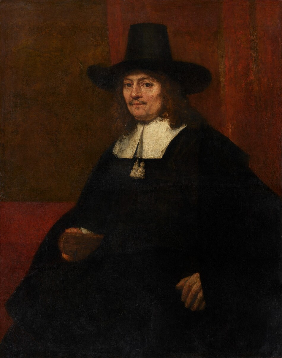 Shown from about the knees up, a man with peachy skin, wearing a voluminous black cloak and a tall, brimmed hat, looks directly at us in this vertical portrait painting. His body is angled to our left and he turns his face to look at us with brown eyes. He has a wispy, brown mustache over his pale pink lips, which are closed. He has a slight double chin and his reddish-brown hair falls to his shoulders. His wide, brimmed hat has a tall crown, which tapers a bit near the top. His black cloak falls over his arms and body, and has a wide, flat, white collar. Two white tassels hang below the split down the front of the collar. His left hand, to our right, is braced against the arm of a chair, and he rests his hand around the wooden end of the chair's arm. The wall behind him is brick-red with a coffee-brown rectangle to our left. Two vertical, fawn-brown stripes run down the red wall to our right, behind the man. Brushstrokes are visible in some areas, as in the man’s face, and a network of cracks runs across the surface of the canvas.